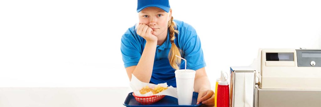 quick service restaurant worker leaning on the counter.