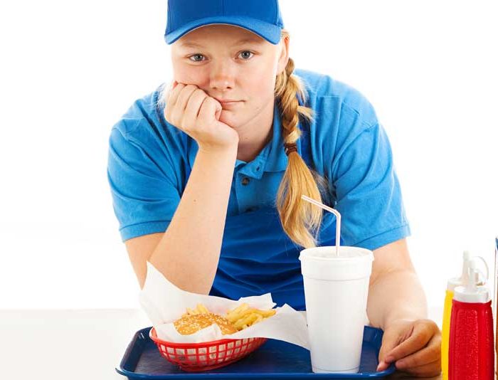 quick service restaurant worker leaning on the counter.